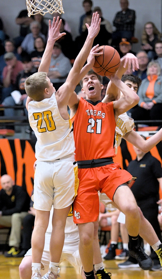 Carson Matzke (21) is heavily guarded on the way to the basket Jan. 30. —Photo by Dave Ender