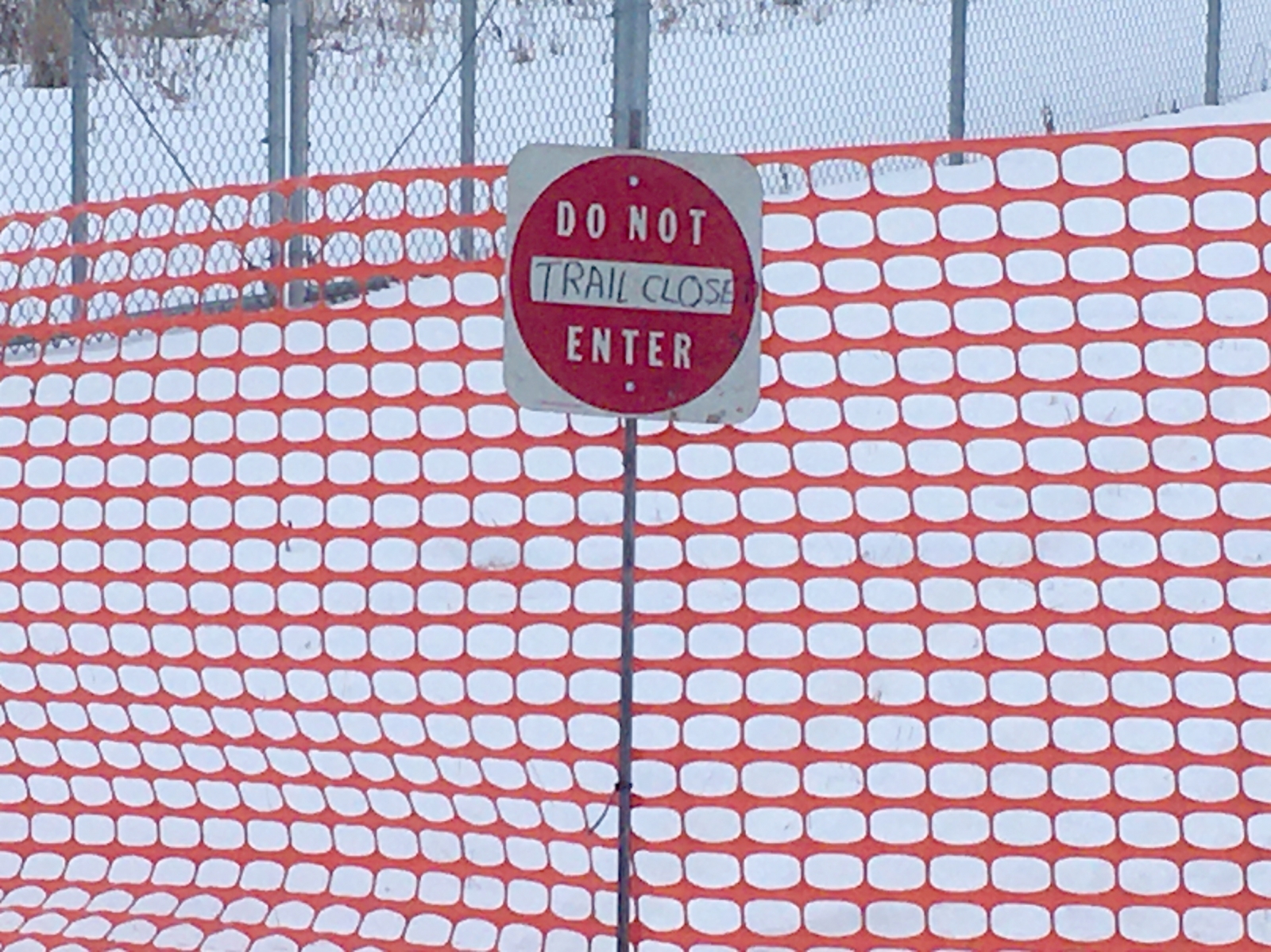 Snow fence creates a barrier on a recently-closed snowmobile trail in Lake City.